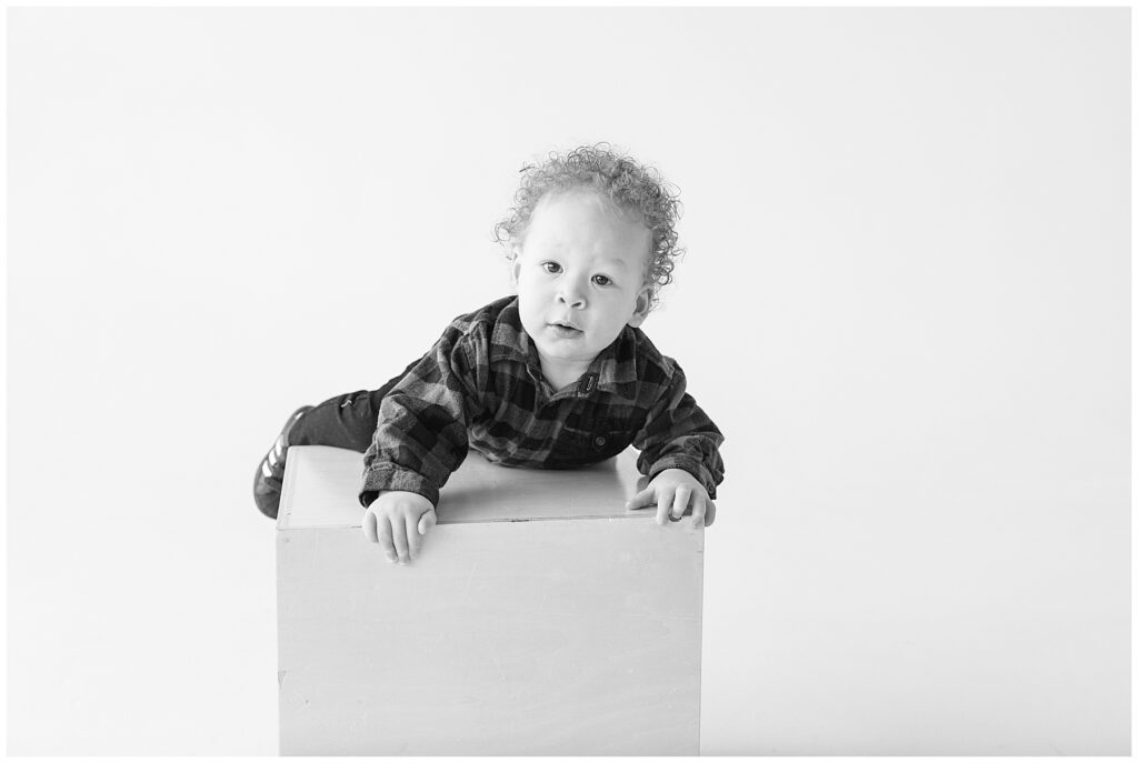 Baby crawling onto a box during these Realm Studio personality portraits in Denver, Colorado