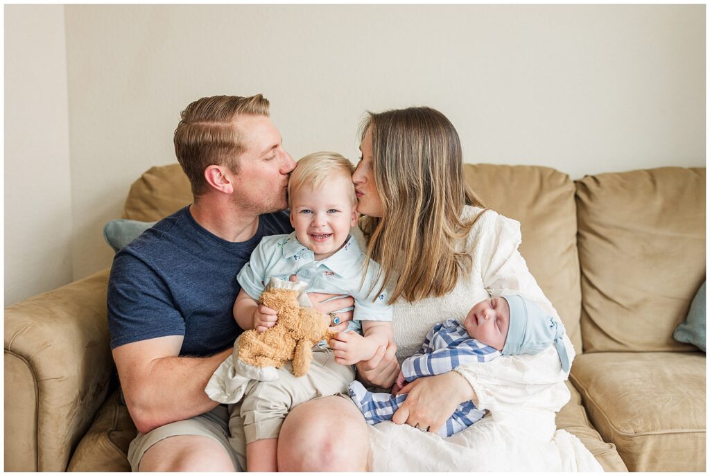 Family of four pose for lifestyle in-home newborn photos