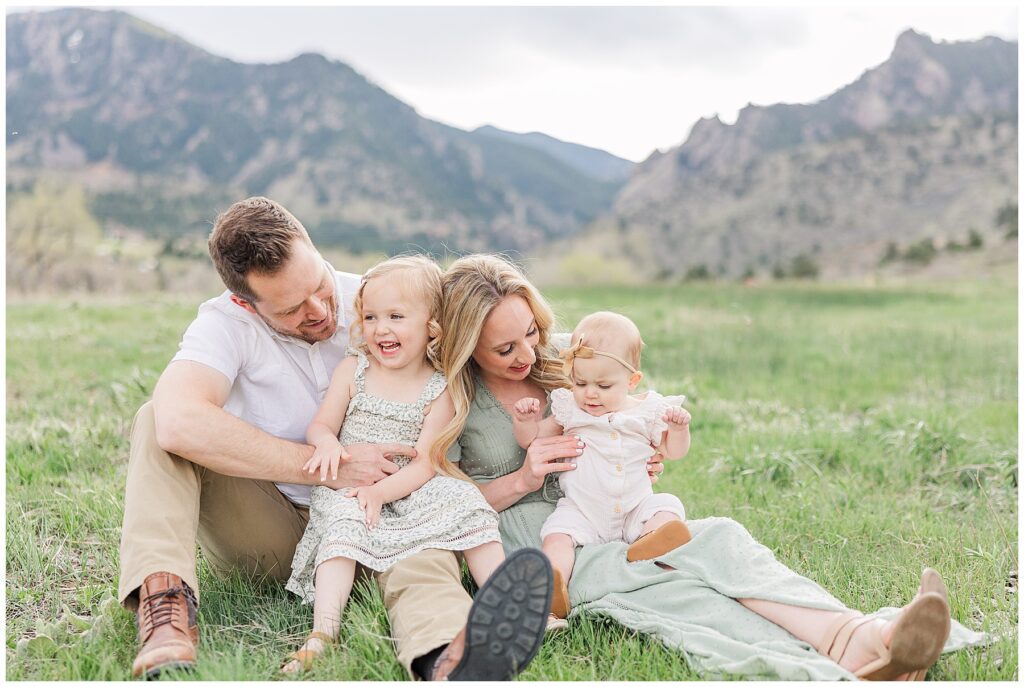 Family looks at one another while posing outside during cake smash photos in Colorado
