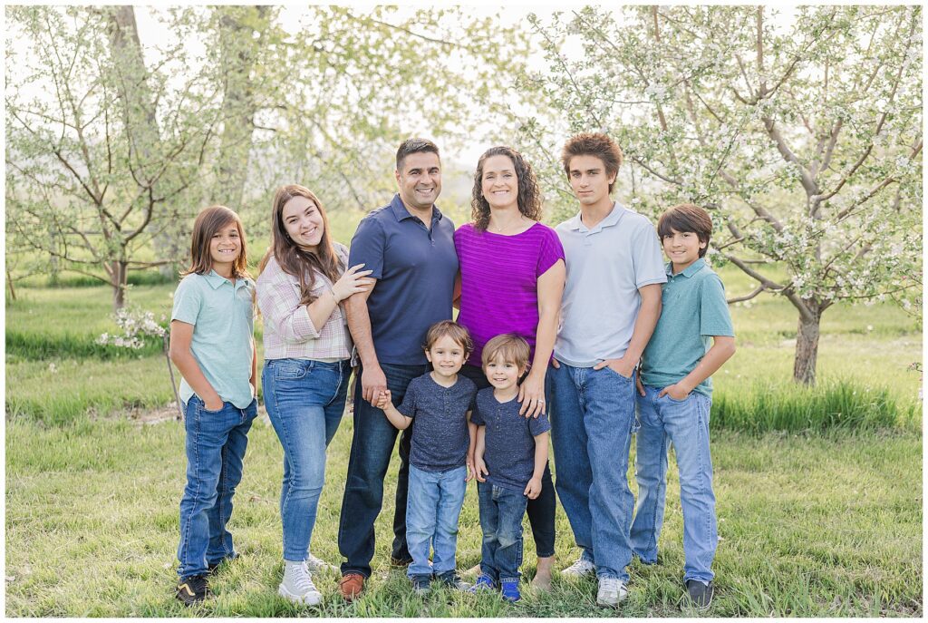 Family of eight pose for spring photos in an orchard