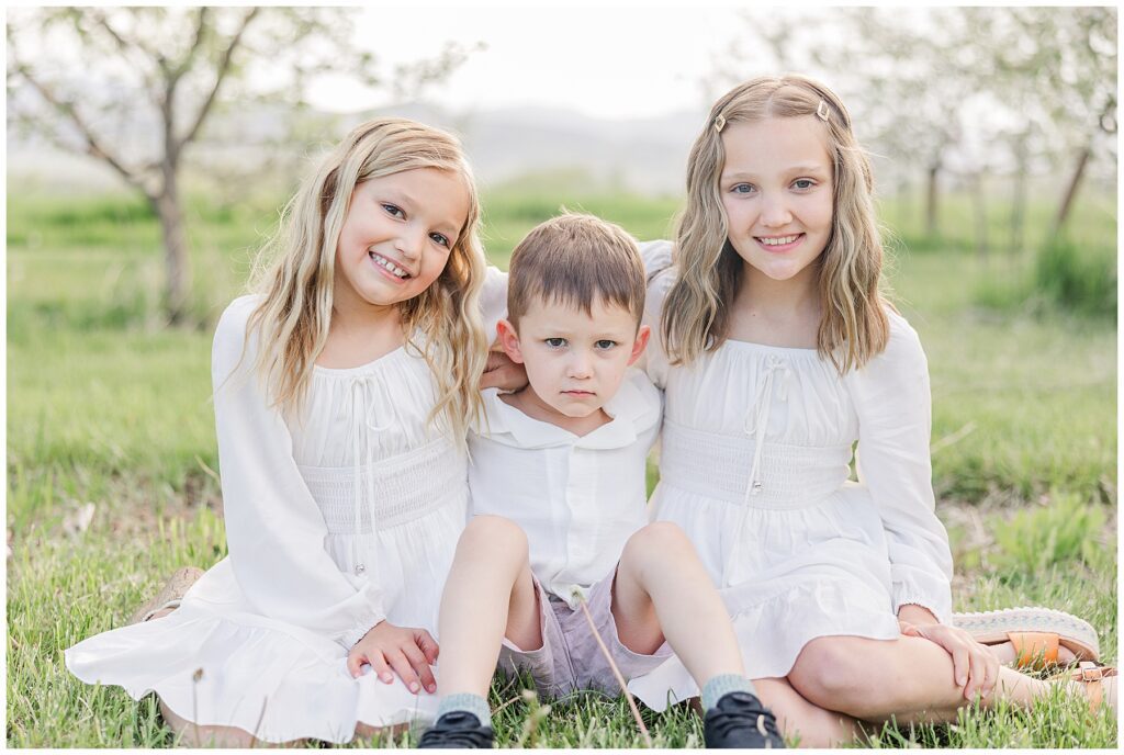 Three children sit facing the camera during photos in Longmont, CO