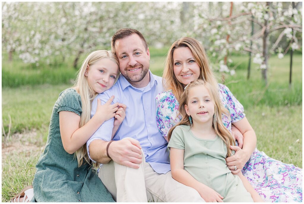 Family of four all sit together smiling for Catherine Chamberlain Photography based in Longmont, CO