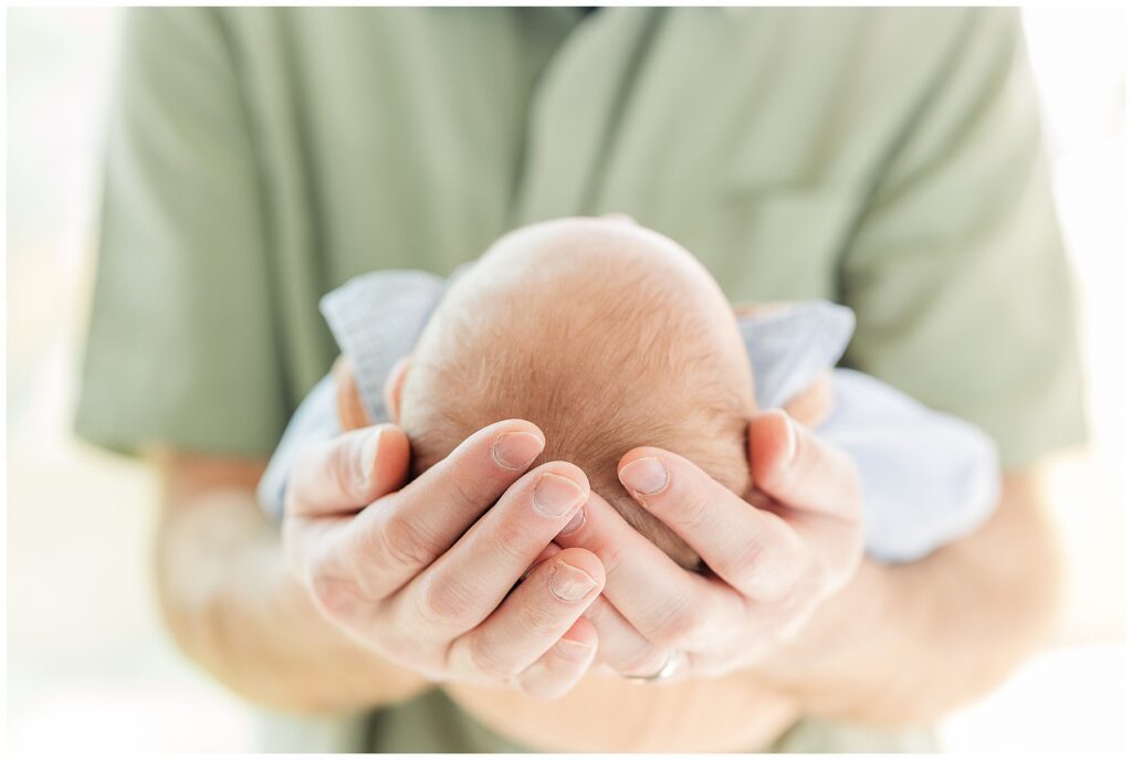 dad holds his newborn in his forearms and is featured in a blog discussing the importance of print
