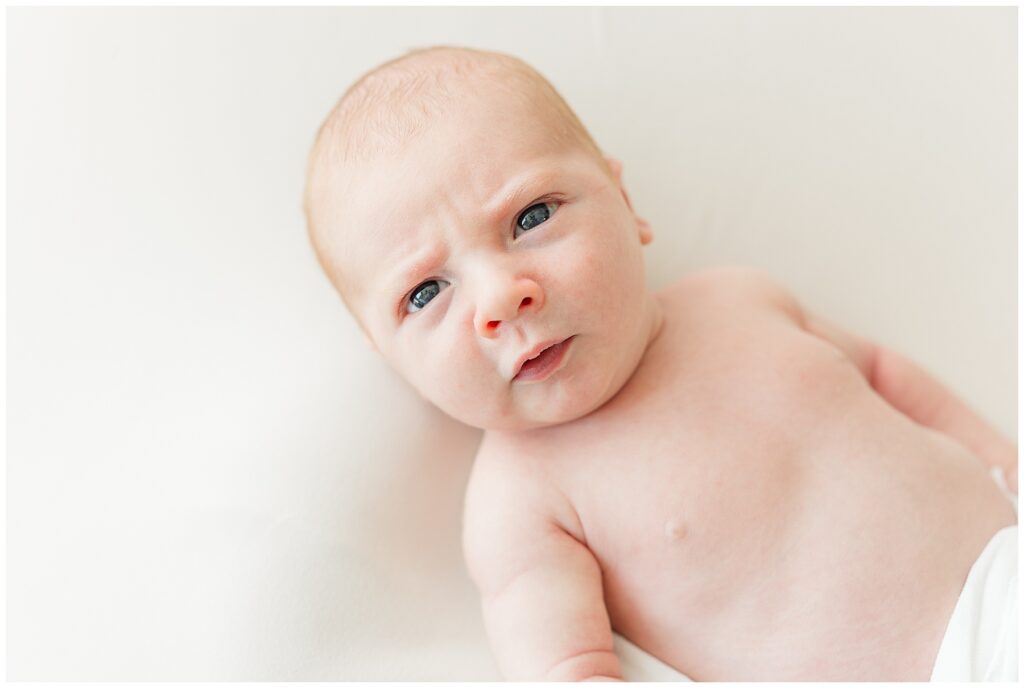 Newborn looks at the camera and is featured in a blog discussing the importance of print