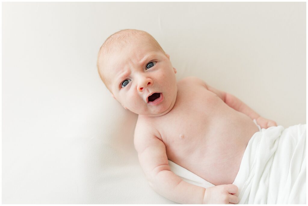 Newborn baby boy yawning while taking photos with Catherine Chamberlain Photography