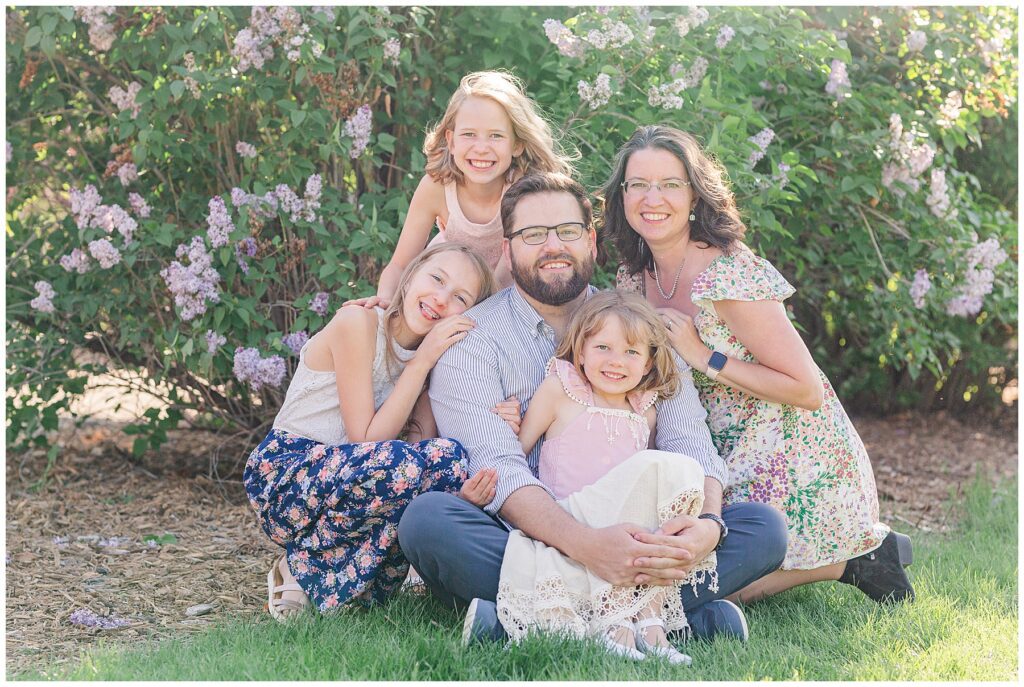 Family of five pose in a garden setting during family photos