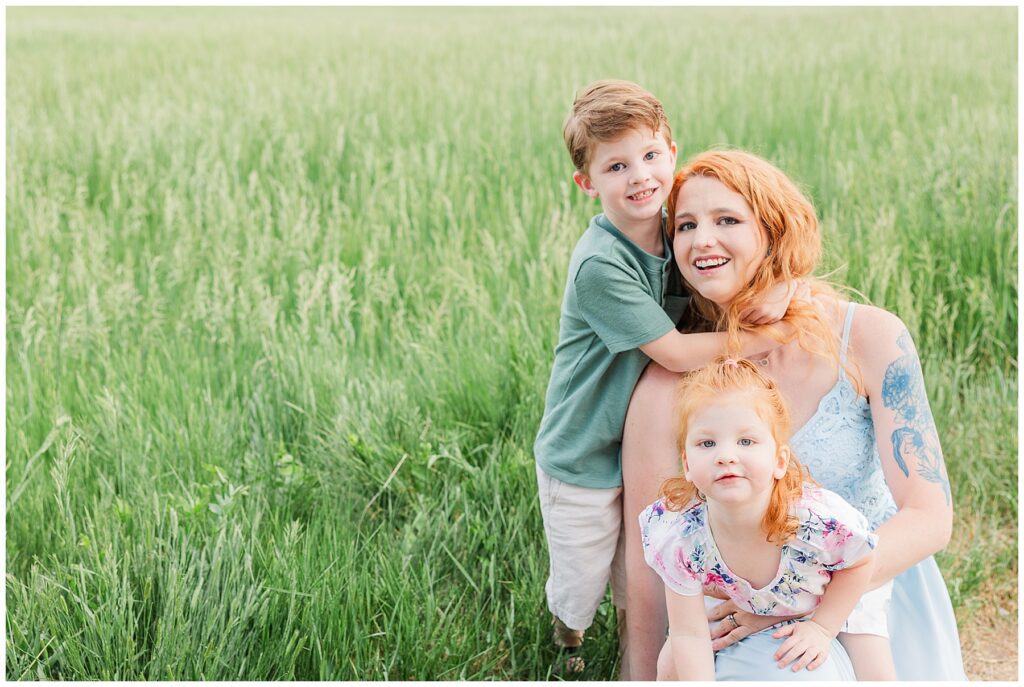 Mom and her two children take a picture in Colorado's green grass