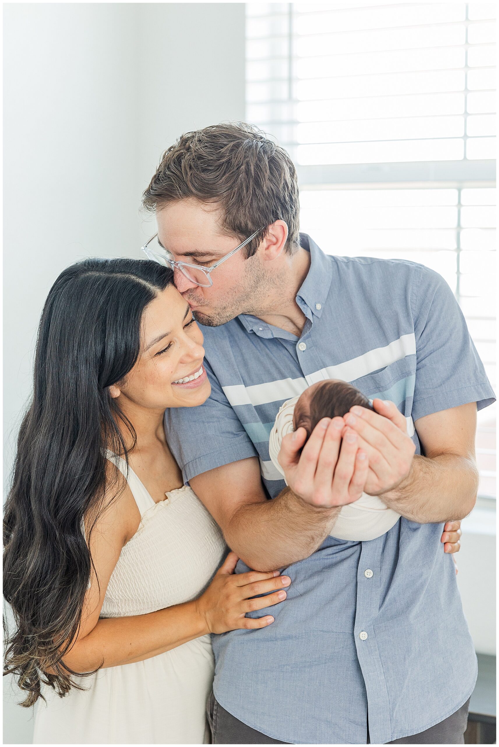 Mom and dad share a tender moment during a dreamy newborn session