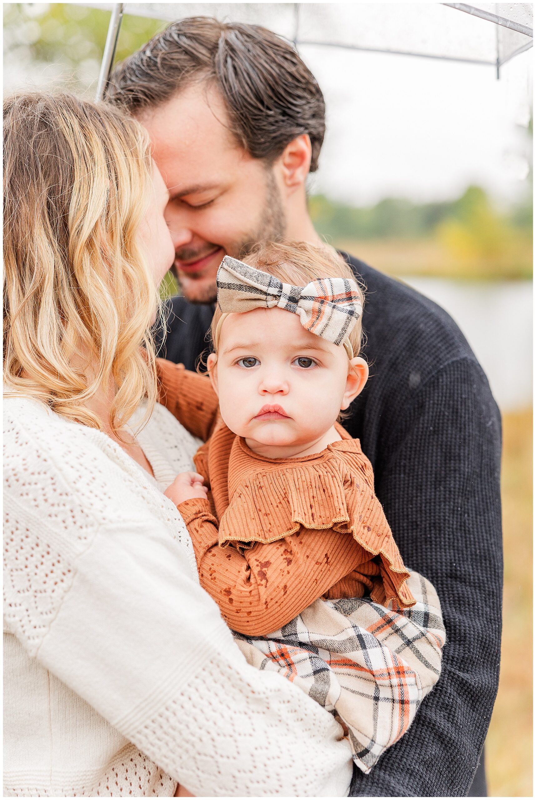 Baby looks at the camera while being held by her parents during my latest mini sessions