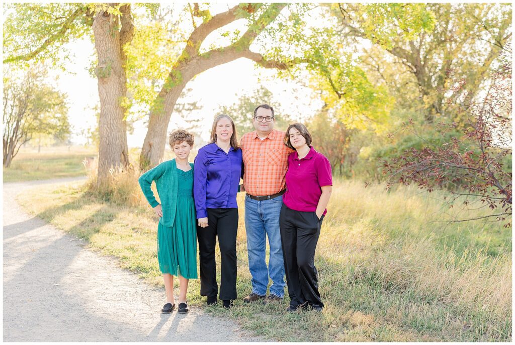 Family of four pose for fall family photos at Jim Hamm Nature Area in Longmont, CO with Catherine Chamberlain Photography