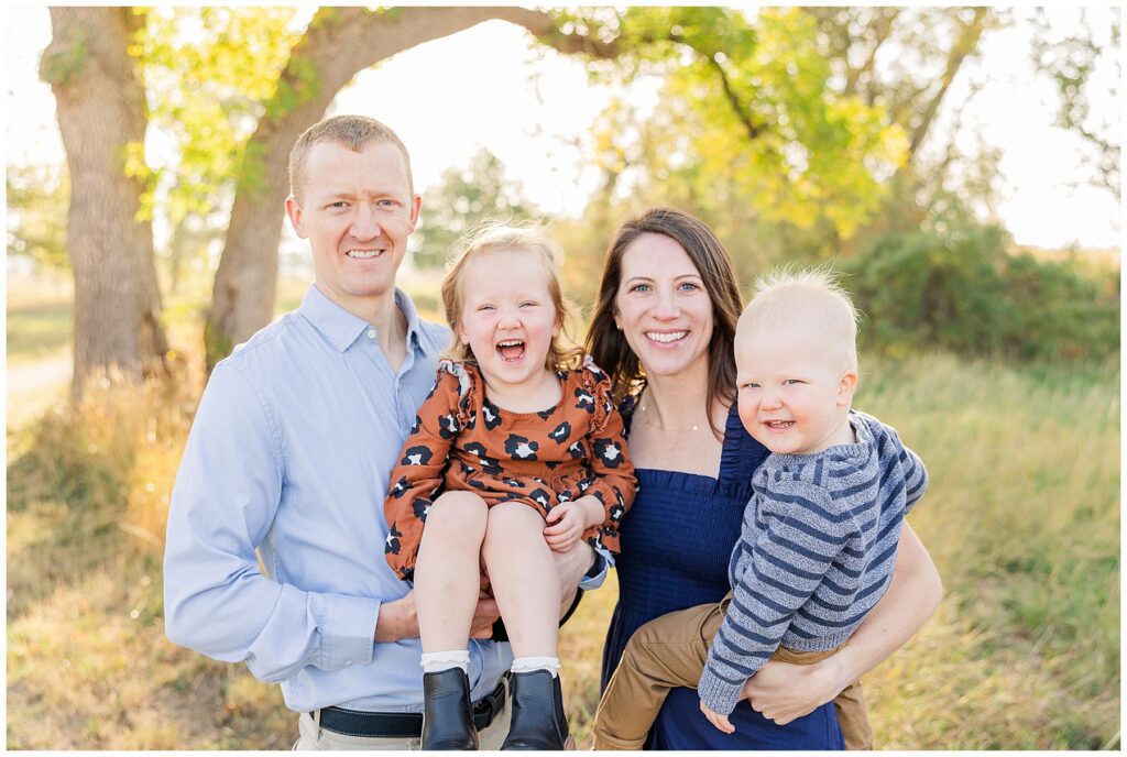 Family of four pose for light and airy outdoor photos at Jim Hamm Nature Area in Longmont, CO