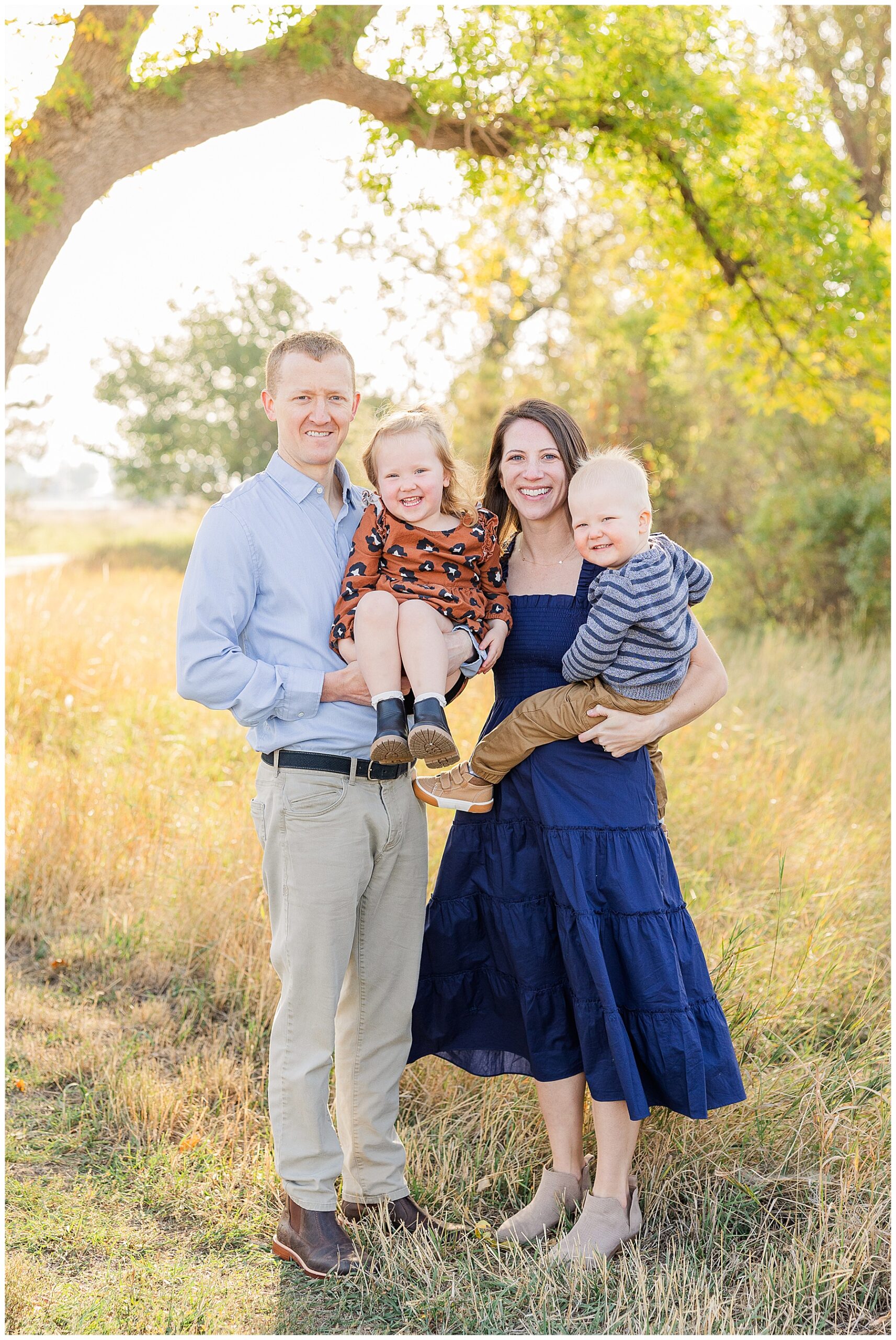 Family of four pose for light and airy fall outdoor photos and are featured in a blog about