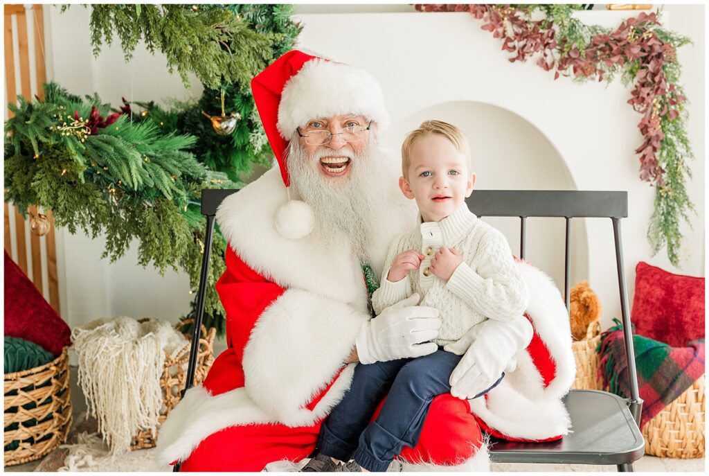 Little boy poses with smiling Santa in Longmont, Colorado