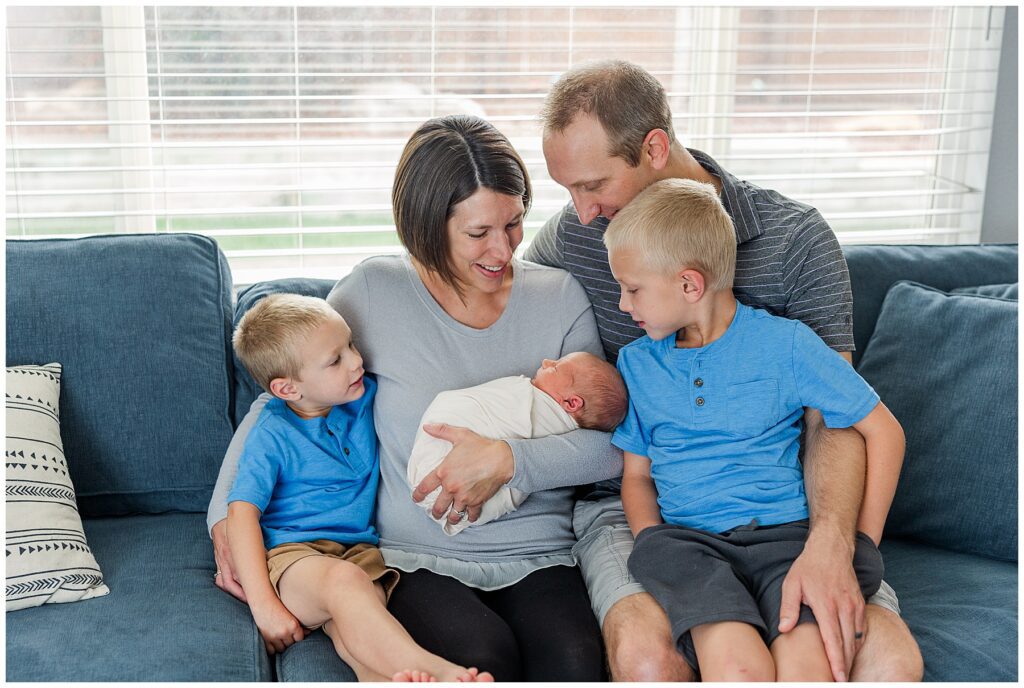 Family of five celebrate their newest member of the family during newborn photoshoot with light and airy family photographer Catherine Chamberlain base in Longmont, Colorado