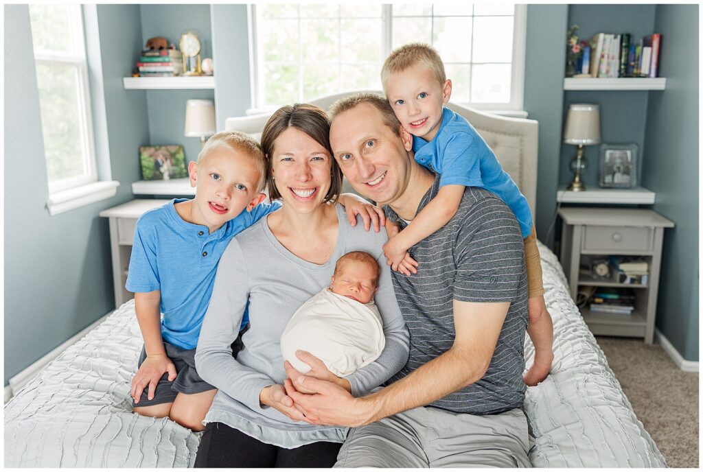 Family of five pose for light and airy newborn photos in Colorado