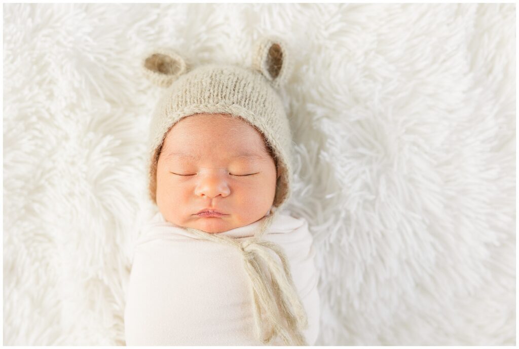 Catherine Chamberlain Photography based out of Longmont captures newborn sleeping in a hat while swaddled